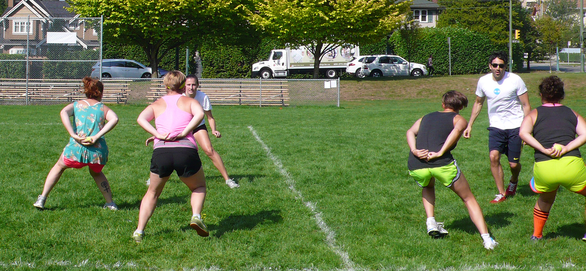 Six personnes portant des vêtements sportifs jouent sur un terrain de sport. Certaines tiennent une balle de tennis dans leurs mains, derrière leur dos. 