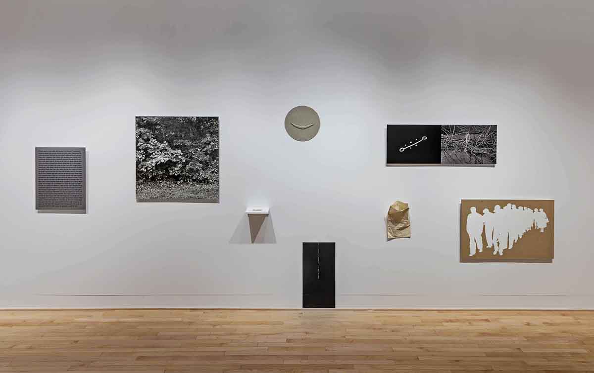 Différentes oeuvres d’art présentées sur un mur de musée blanc. 